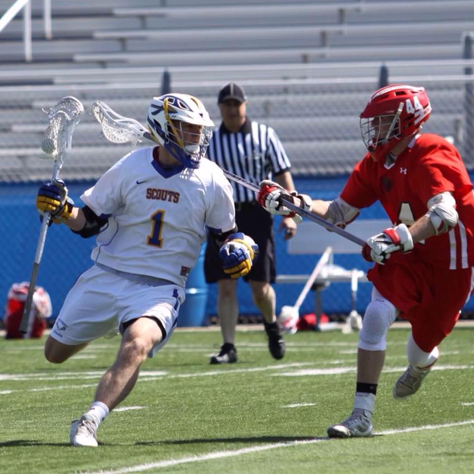 Two lacrosse players on opposing teams playing on field