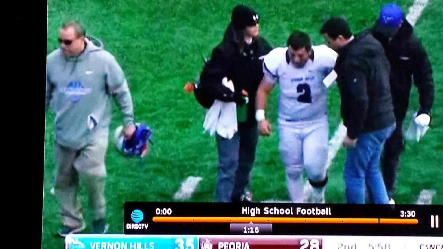 Football player walking off field after being injured