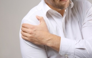 Man holding shoulder in pain.
