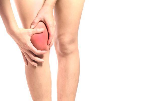 Women holding inflamed knee in pain