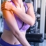 woman holding her shoulder while she does rotator cuff exercises at the gym